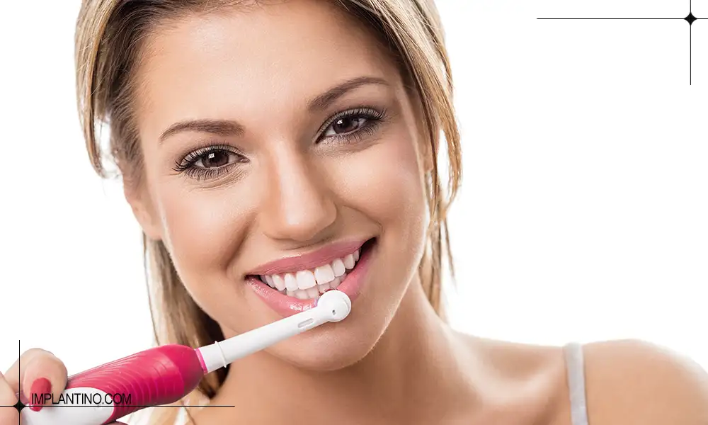 خانمی در حال مسواک زدن با مسواک برقی