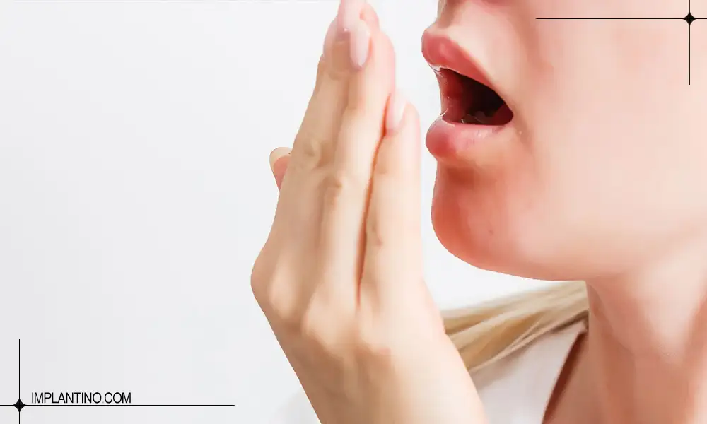 دلیل بوی بد دهان و راه های درمان آن 2 متنوجه شدن بوی بد دهان خانمی که دست خود را جلوی دهانش گرفته است.